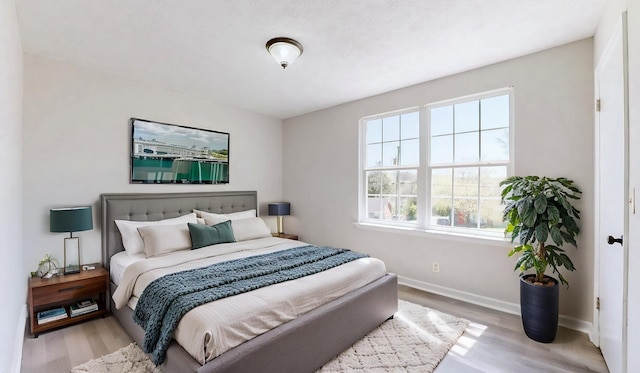 bedroom with wood finished floors and baseboards