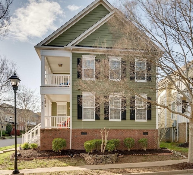 view of front of property with a porch, a balcony, and crawl space