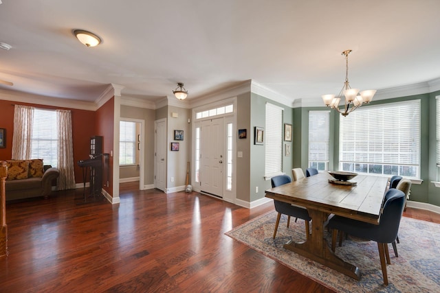 dining room featuring a chandelier, crown molding, wood finished floors, and baseboards