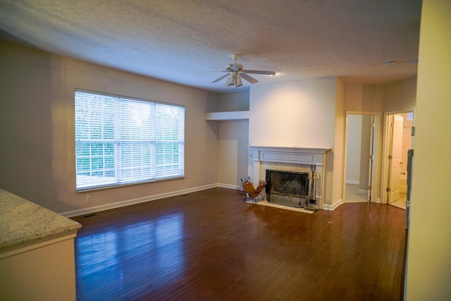 unfurnished living room featuring ceiling fan, baseboards, wood finished floors, and a fireplace