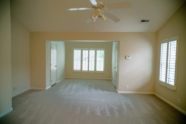 carpeted empty room featuring visible vents, baseboards, and ceiling fan