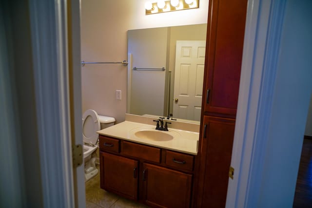 bathroom featuring tile patterned flooring, vanity, and toilet