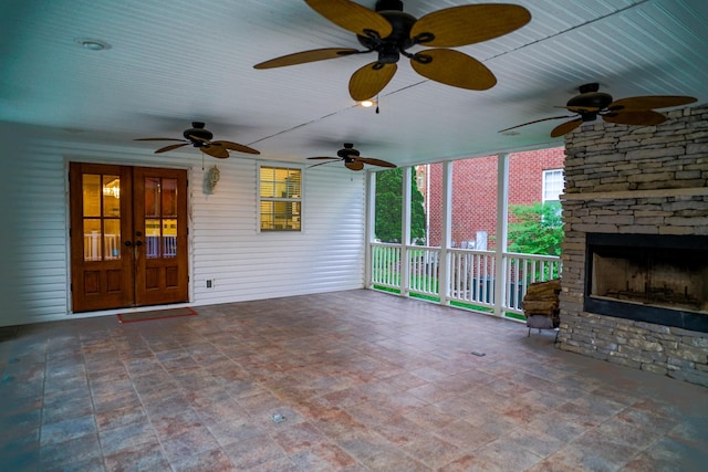 view of patio with french doors and a stone fireplace