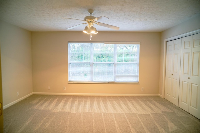 unfurnished bedroom with carpet floors, baseboards, and a textured ceiling