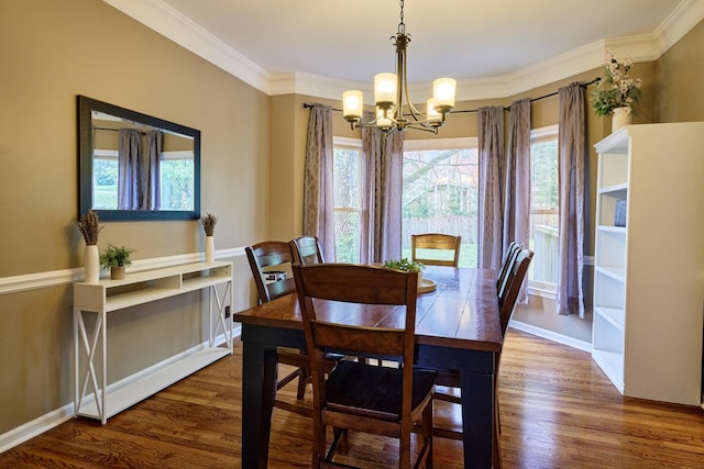 dining room with a notable chandelier, baseboards, ornamental molding, and wood finished floors
