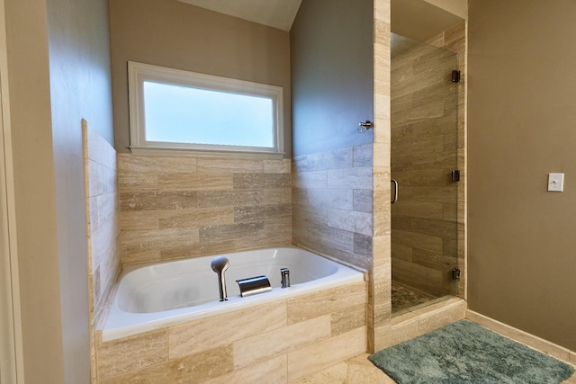 full bath featuring baseboards, a shower stall, and a garden tub