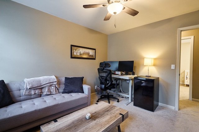 office area featuring light colored carpet, baseboards, and a ceiling fan