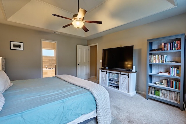 carpeted bedroom with baseboards, ensuite bath, visible vents, a tray ceiling, and ceiling fan