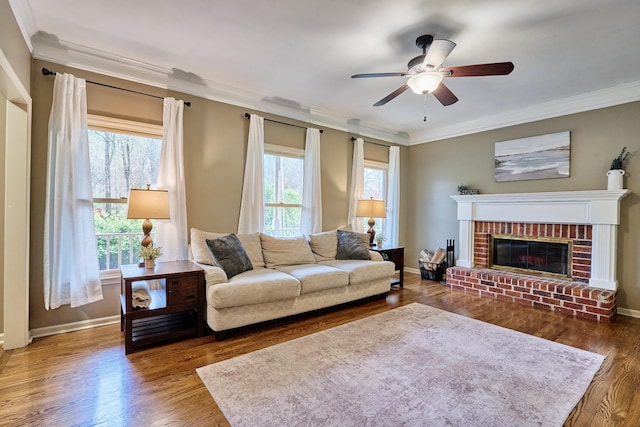 living room with a wealth of natural light, ornamental molding, and ceiling fan