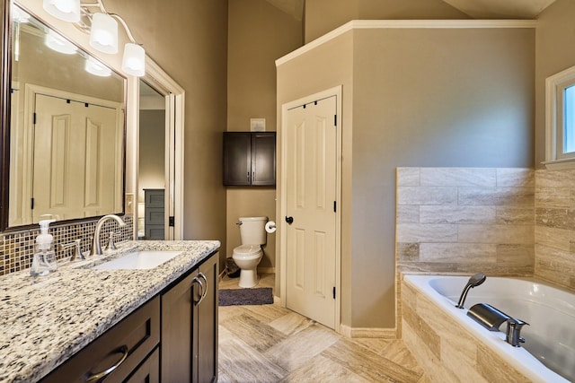 bathroom with tasteful backsplash, vanity, baseboards, toilet, and a garden tub