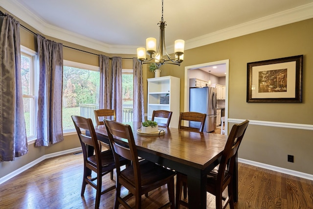 dining room with a notable chandelier, wood finished floors, and a healthy amount of sunlight