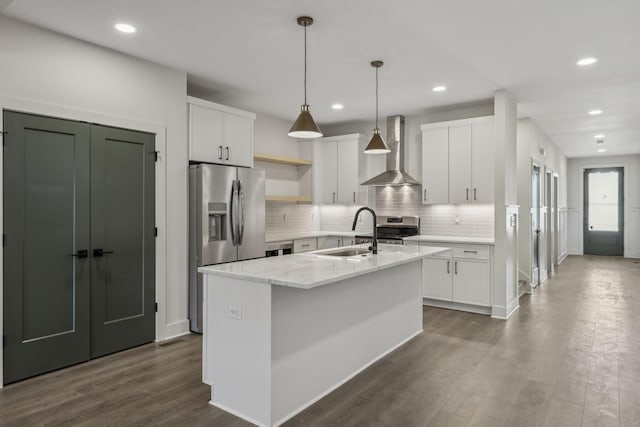 kitchen featuring dark wood finished floors, wall chimney range hood, open shelves, a sink, and stainless steel appliances