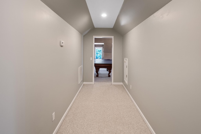 hall with baseboards, light carpet, and lofted ceiling