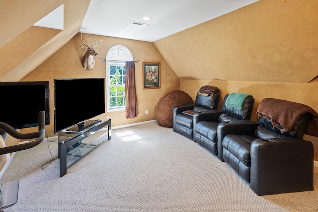 carpeted home theater featuring baseboards, vaulted ceiling, and visible vents