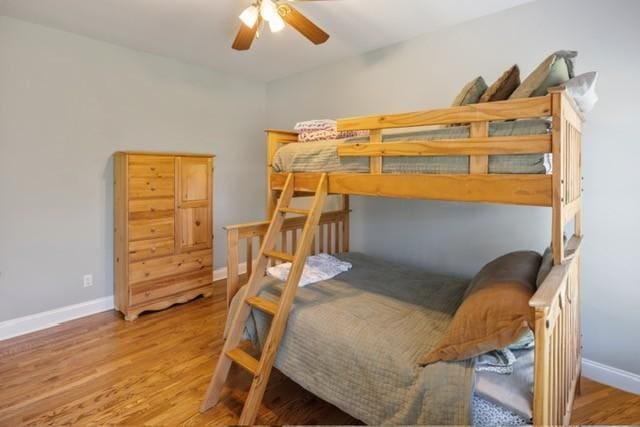 bedroom featuring wood finished floors, baseboards, and a ceiling fan