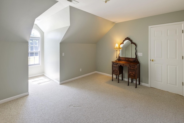 additional living space featuring lofted ceiling, visible vents, baseboards, and carpet floors