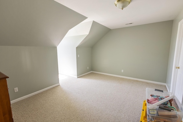 additional living space featuring baseboards, lofted ceiling, visible vents, and carpet floors