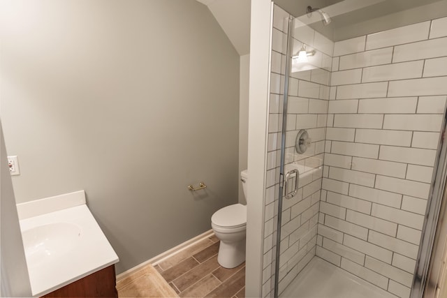 bathroom featuring vanity, baseboards, wood finish floors, toilet, and a shower stall