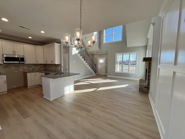 19 Faith Ln, Lebanon, TN 37087 - kitchen with stainless steel microwave, a peninsula, baseboards, white cabinetry, and open floor plan