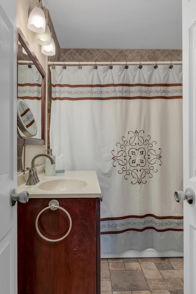 bathroom featuring vanity, a shower with shower curtain, and stone tile flooring
