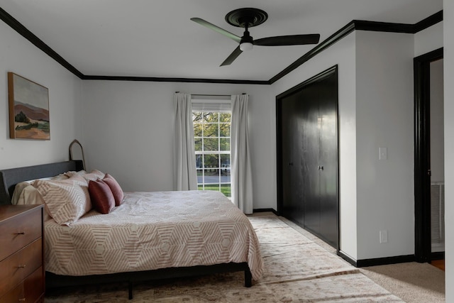 bedroom featuring crown molding, baseboards, a ceiling fan, and light colored carpet
