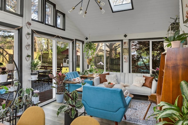 sunroom / solarium with vaulted ceiling with skylight and wood finished floors