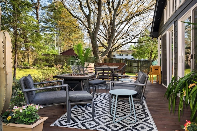 wooden terrace featuring outdoor dining area and a fenced backyard