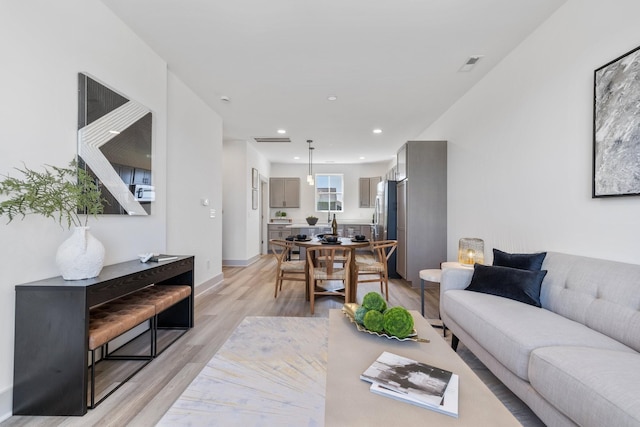 living area featuring recessed lighting, light wood-style flooring, baseboards, and visible vents