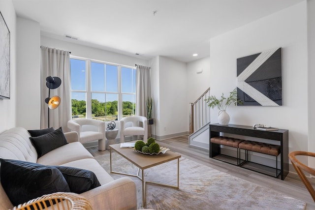 living room featuring visible vents, baseboards, recessed lighting, stairway, and wood finished floors