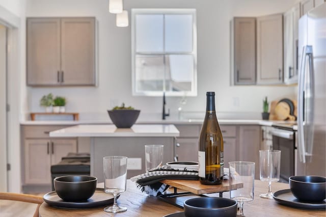 kitchen featuring stainless steel refrigerator, dishwashing machine, light countertops, and wood finished floors
