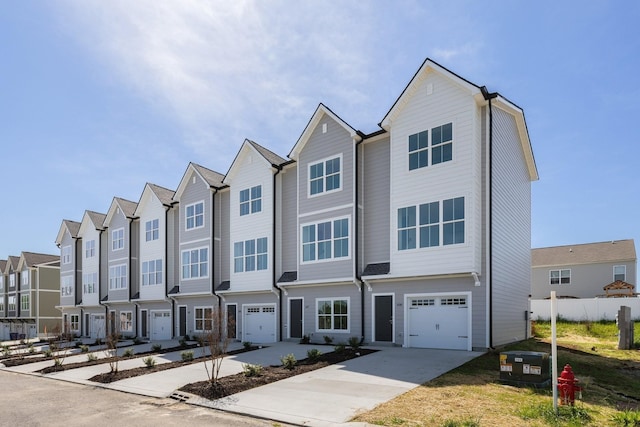 townhome / multi-family property featuring an attached garage, driveway, and a residential view