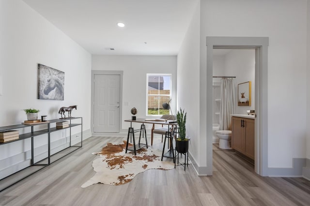 interior space with baseboards, light wood-type flooring, and recessed lighting