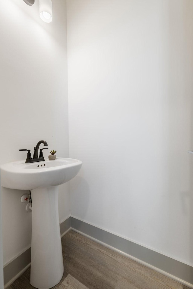 bathroom with baseboards and wood finished floors