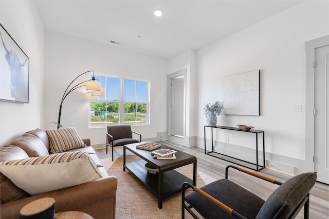 living area featuring light wood-style flooring, baseboards, visible vents, and recessed lighting