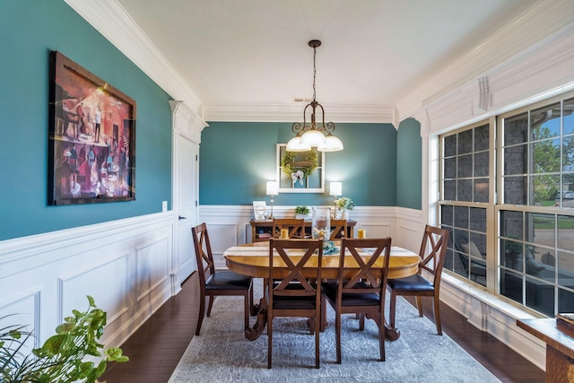 dining space with crown molding, a wainscoted wall, a chandelier, and wood finished floors
