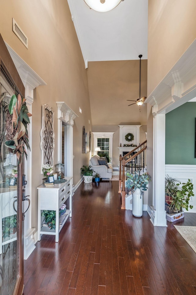 entryway with decorative columns, stairway, visible vents, and a ceiling fan