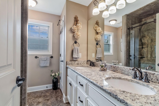 full bath with a shower stall, baseboards, and a sink