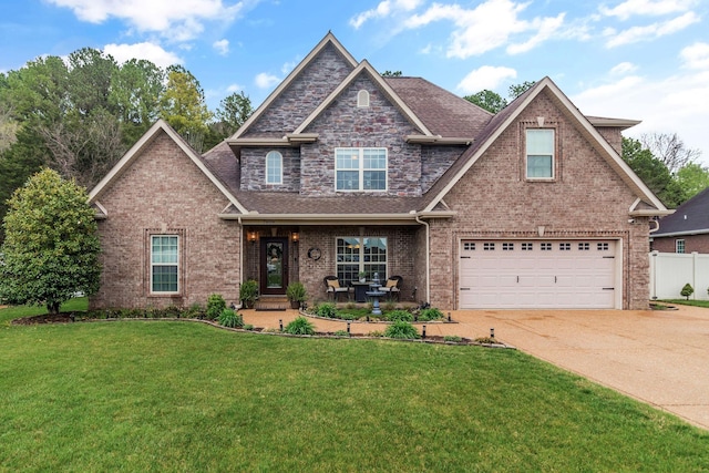 view of front of home featuring concrete driveway, an attached garage, a front yard, brick siding, and fence