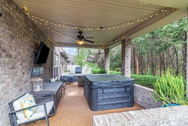 view of patio with ceiling fan and a hot tub