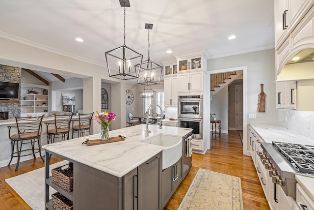 620 Williamson County Line Rd, Fairview, TN 37062 - kitchen featuring a sink, a chandelier, a fireplace, stainless steel appliances, and light wood-style flooring