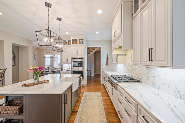 620 Williamson County Line Rd, Fairview, TN 37062 - kitchen featuring glass insert cabinets, appliances with stainless steel finishes, a chandelier, light wood-style floors, and backsplash