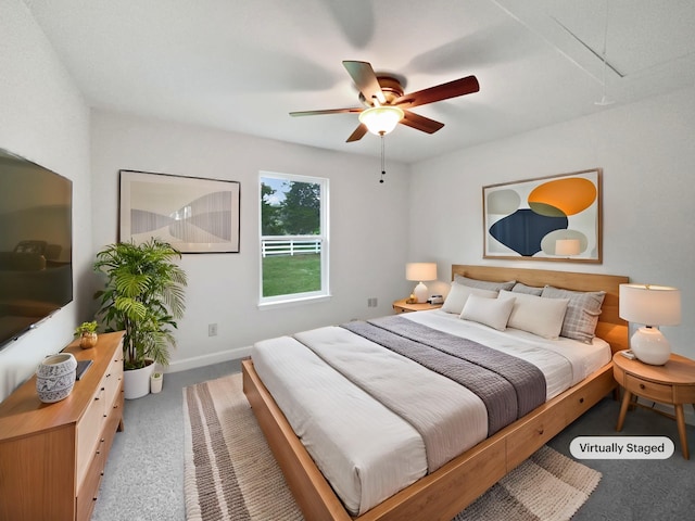 carpeted bedroom with attic access, baseboards, and a ceiling fan