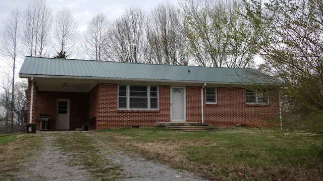 ranch-style home featuring a carport, driveway, a front lawn, brick siding, and metal roof