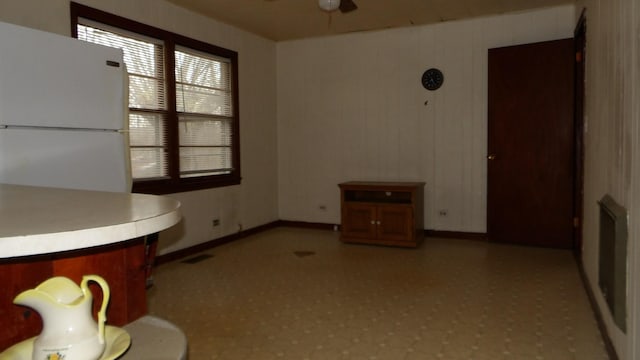 unfurnished dining area featuring a ceiling fan, visible vents, and light floors