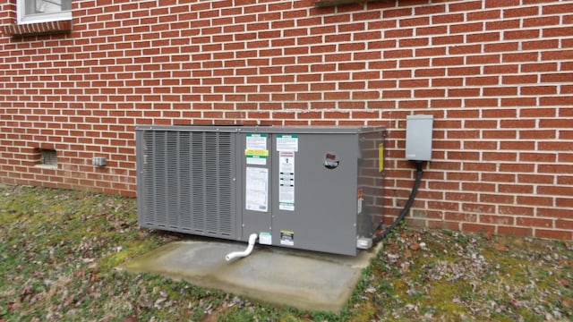 exterior details with central AC unit, mail area, and brick siding