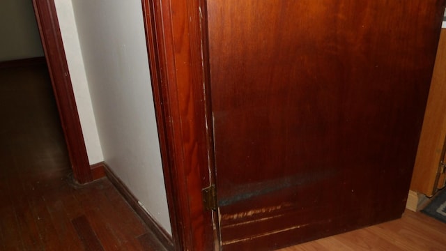 hallway with baseboards and wood finished floors