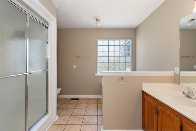bathroom with a shower stall, tile patterned flooring, visible vents, toilet, and vanity