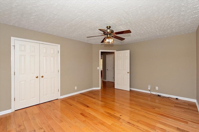 unfurnished bedroom featuring light wood-type flooring, a closet, a ceiling fan, and baseboards