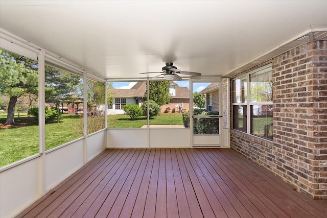 unfurnished sunroom featuring ceiling fan