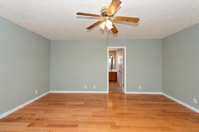 empty room featuring light wood-type flooring, a textured ceiling, baseboards, and ceiling fan